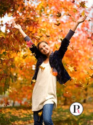 teen girl throwing leaves in autumn